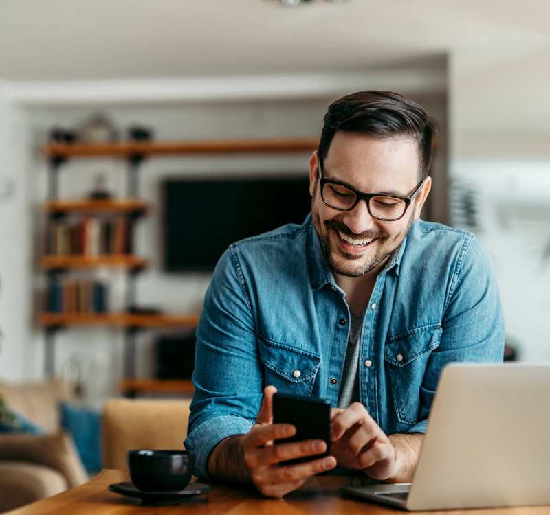 Mann mit Brille schaut auf Smartphone