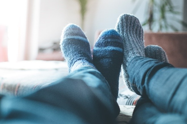 Zwei Menschen legen Ihre Füße hoch, welche in dicken Socken gehüllt sind
