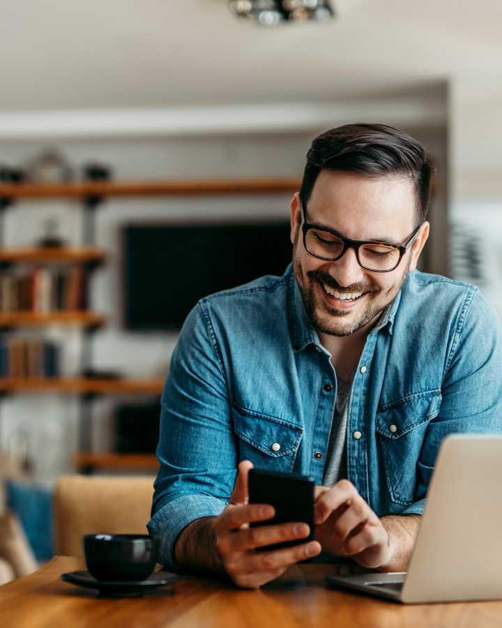 Mann mit Brille schaut auf Smartphone