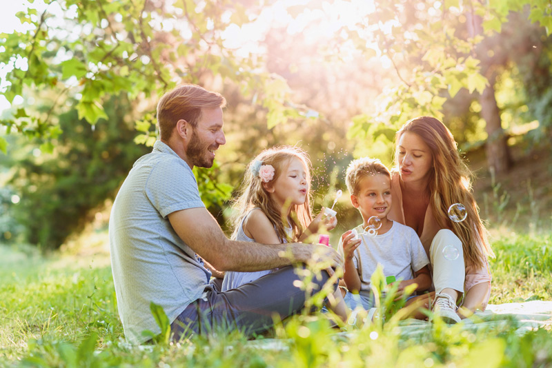 Familie im Park pusten Seifenblasen